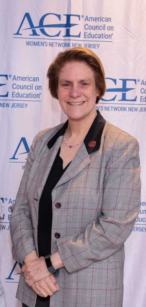 Dr. Cindy Jebb smiling in front of NJ ACE backdrop